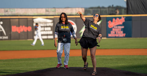 a woman throwing out the first pitch at a baseball game