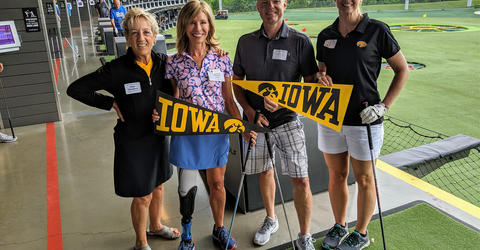 University of Iowa alumna Deborah Smith stands with three friends at a golf facility