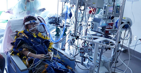 a patient on extracorporeal membrane oxygenation sits in a hospital room