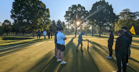 students preparing a golf course for a tournament