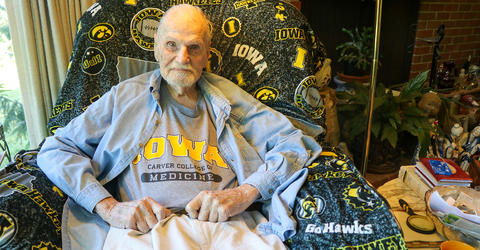 university of iowa carver college of medicine alum rufus kruse sitting in his home wearing an alum t-shirt
