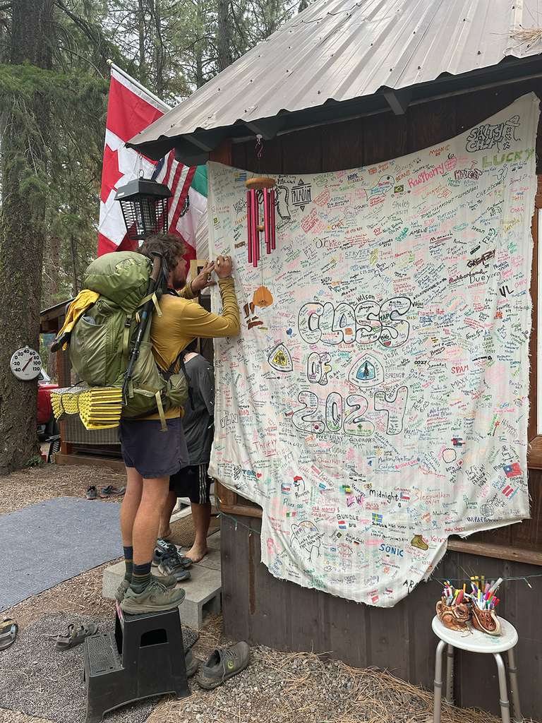 a man signing a sign along the Pacific Crest Trail