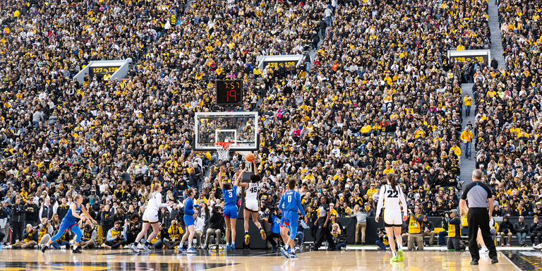 Hannah Stuelke goes strong to the hoop; thousands of fans are visible in the background