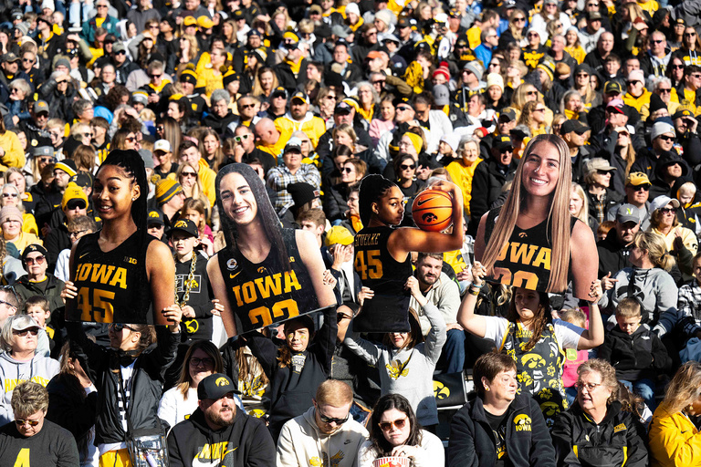 fans holding up cardboard images of Iowa players
