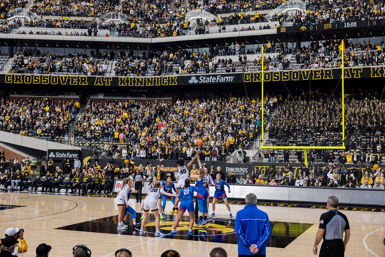 a basketball game played outdoors at Kinnick Stadium on the University of Iowa campus, featuring Caitlin Clark and the Iowa Hawkeyes against DePaul University