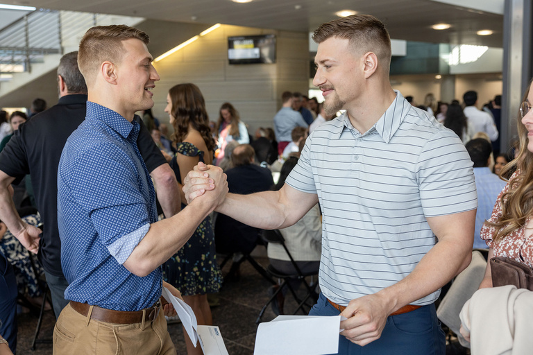 Two men high-fiving each other
