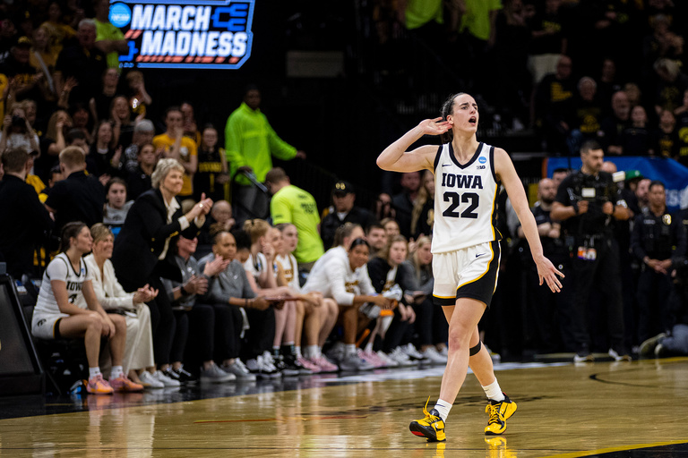 Caitlin Clark cups her hand around her ear during a game at Carver-Hawkeye Arena