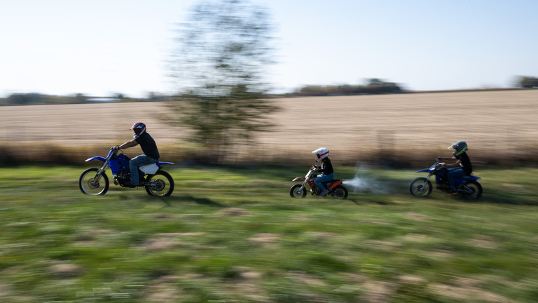 three people riding motorcycles