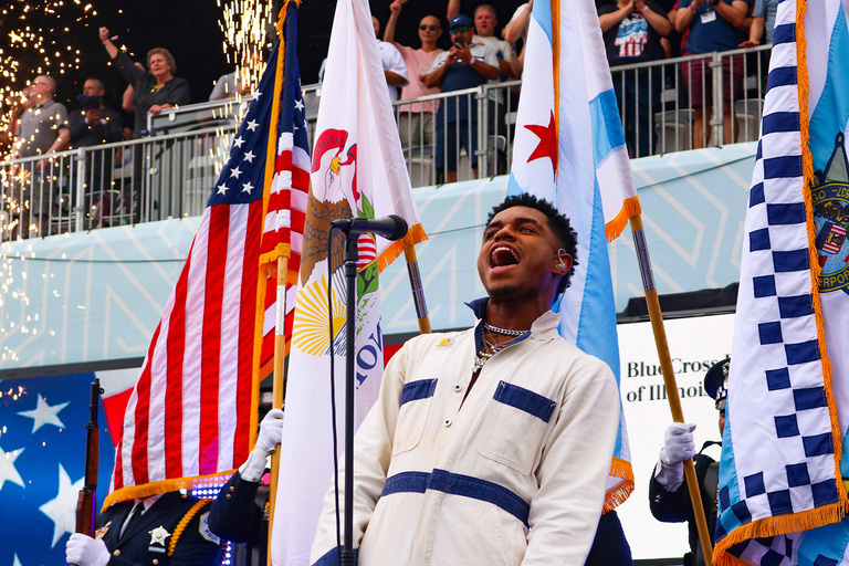 a man sings the national anthem at a nascar race in Chicago