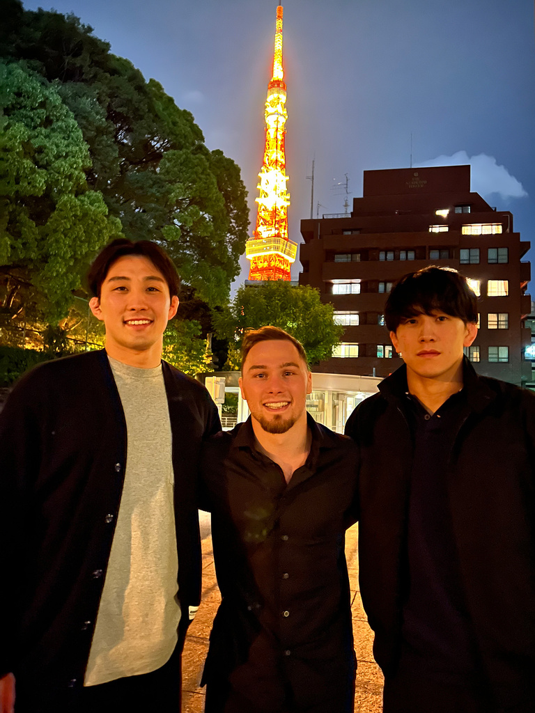 Three men standing together and smiling
