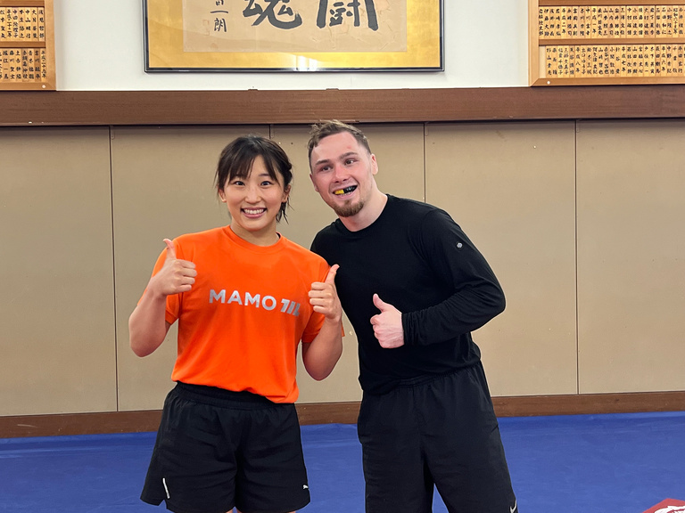A man and a woman smiling together as they give a thumbs up to the camera