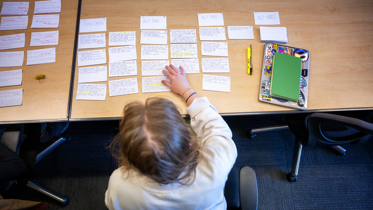 a student looking at index cards during a screenwriting class