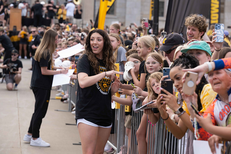 A woman talking to a group of fans