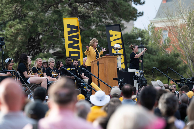 A woman speaking with her hands up to a crowd