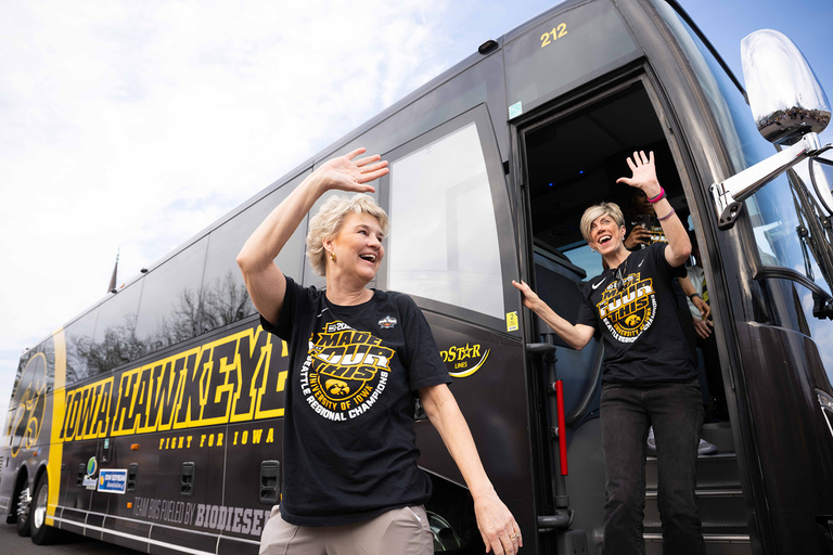 Tow women walking out of a bus waving
