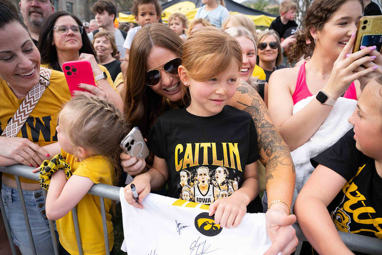A young girl standing with an autographed shirt