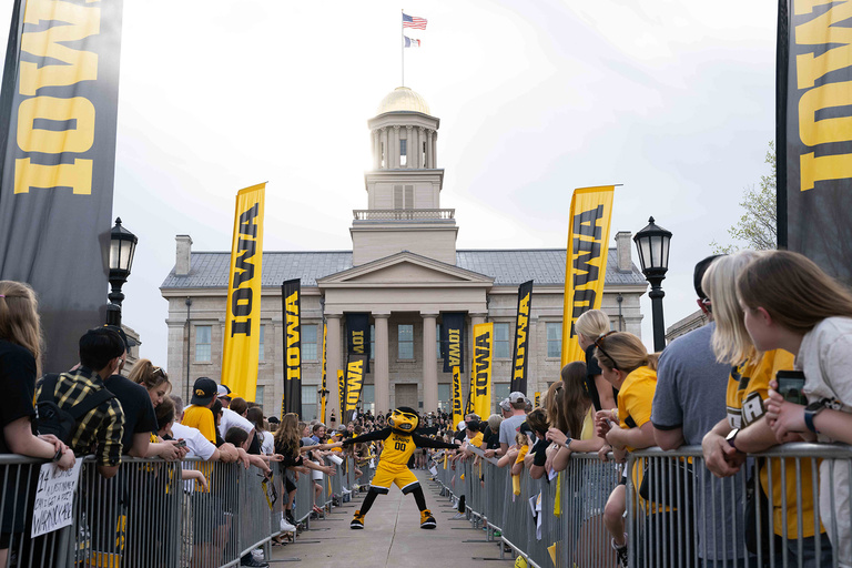 Herky running down an aisle of people