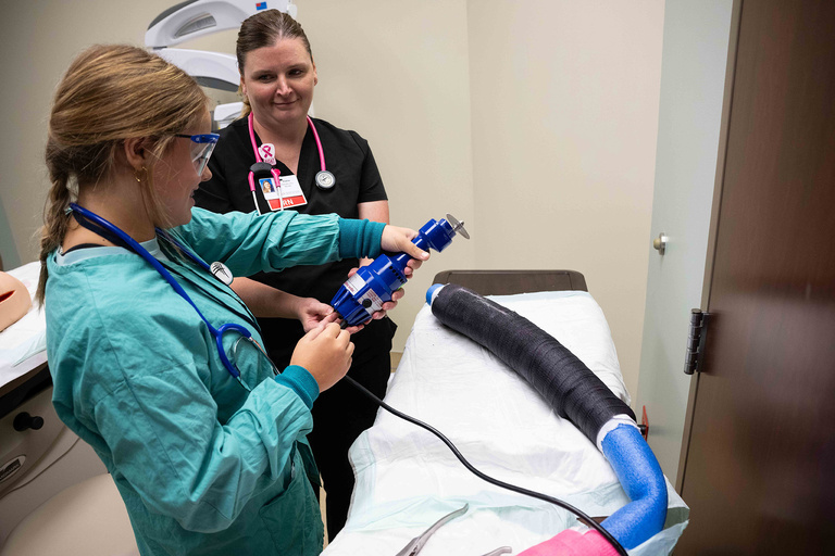 A student practicing how to cut a cast