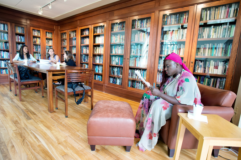 A woman reading and a group studying behind her
