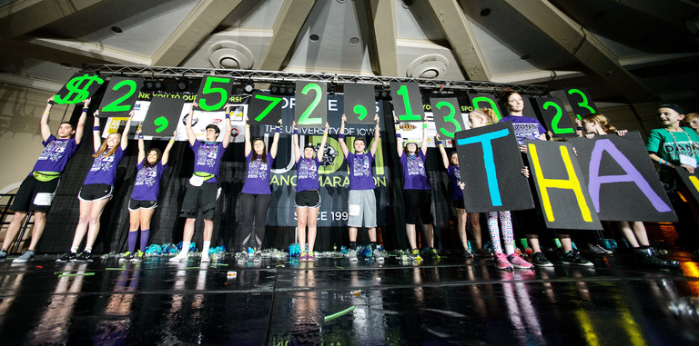 A group of people holding up signs with a dollar amount on them