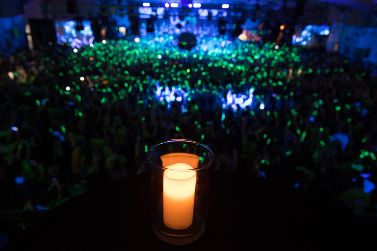 A candle sitting on a ledge over a crowd