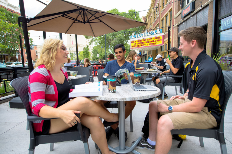A group of people sitting outside and smiling