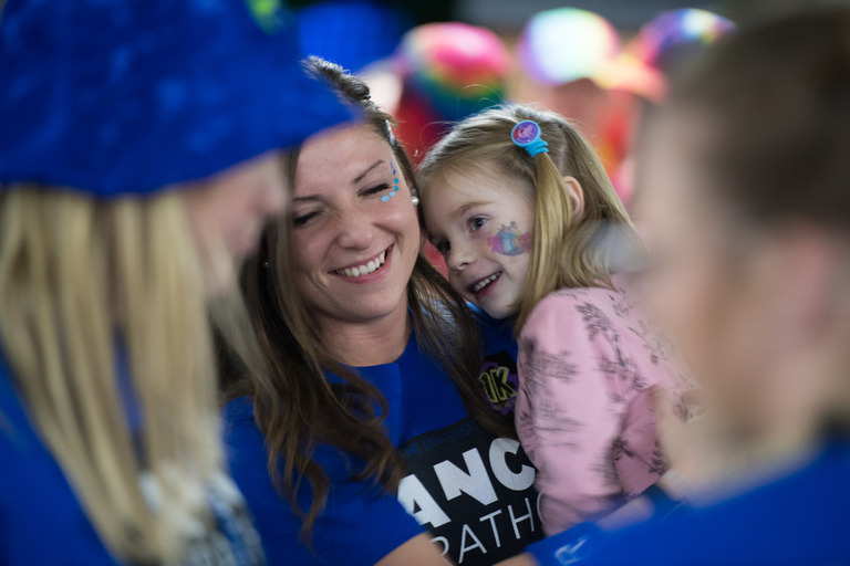A young girl smiling while being held up
