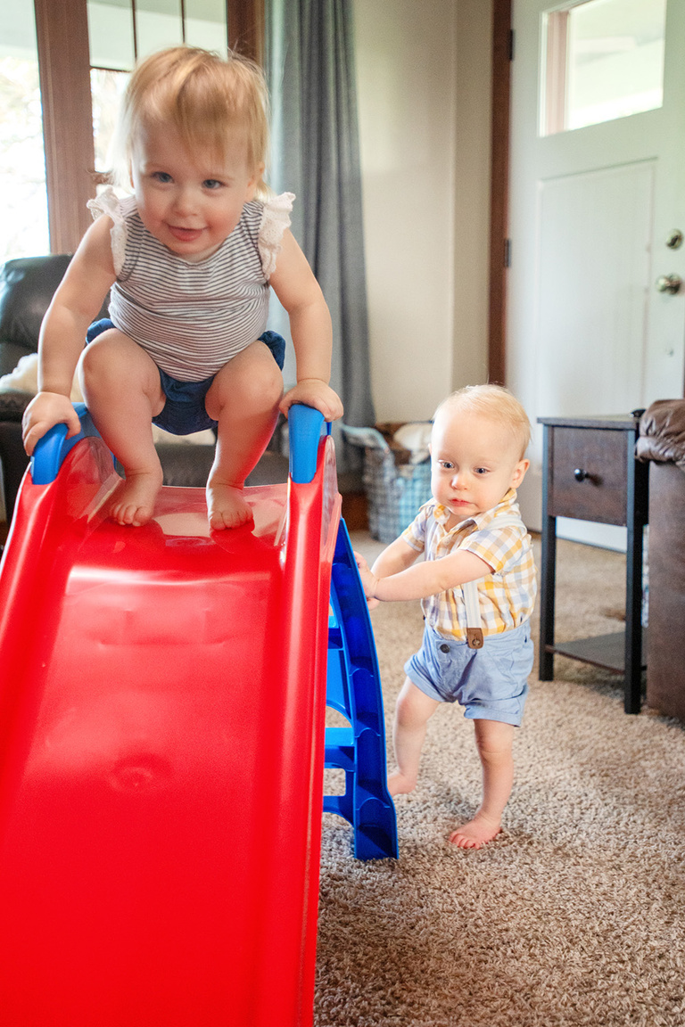 toddlers playing on a small toy slide