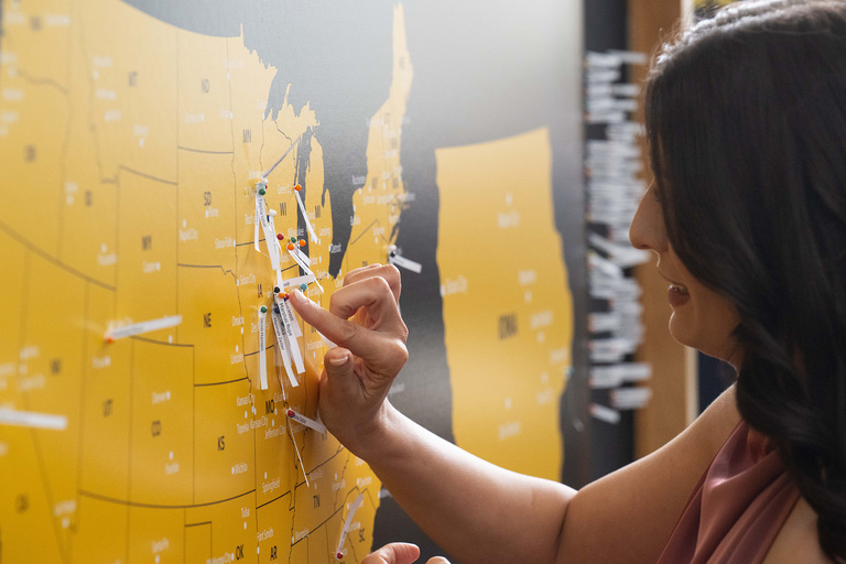 A woman placing a pin on a map of the united states