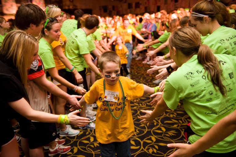 A young child running through a high-five line