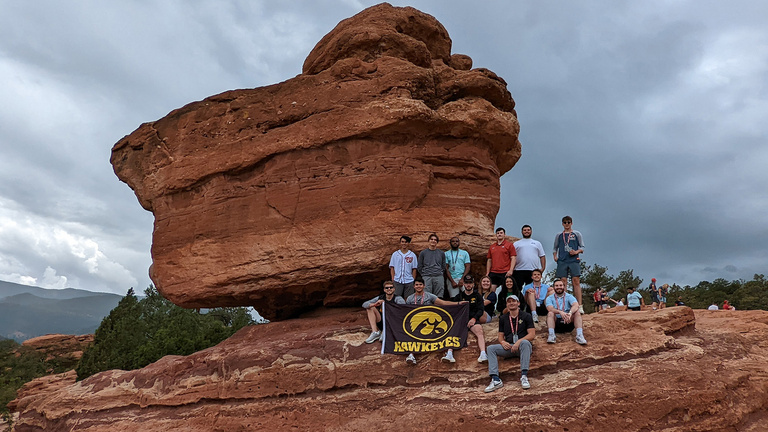students posing near a rock formation