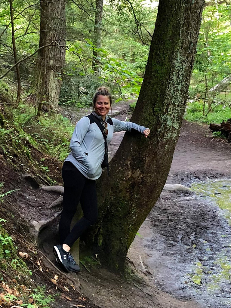 a woman leaning against a tree