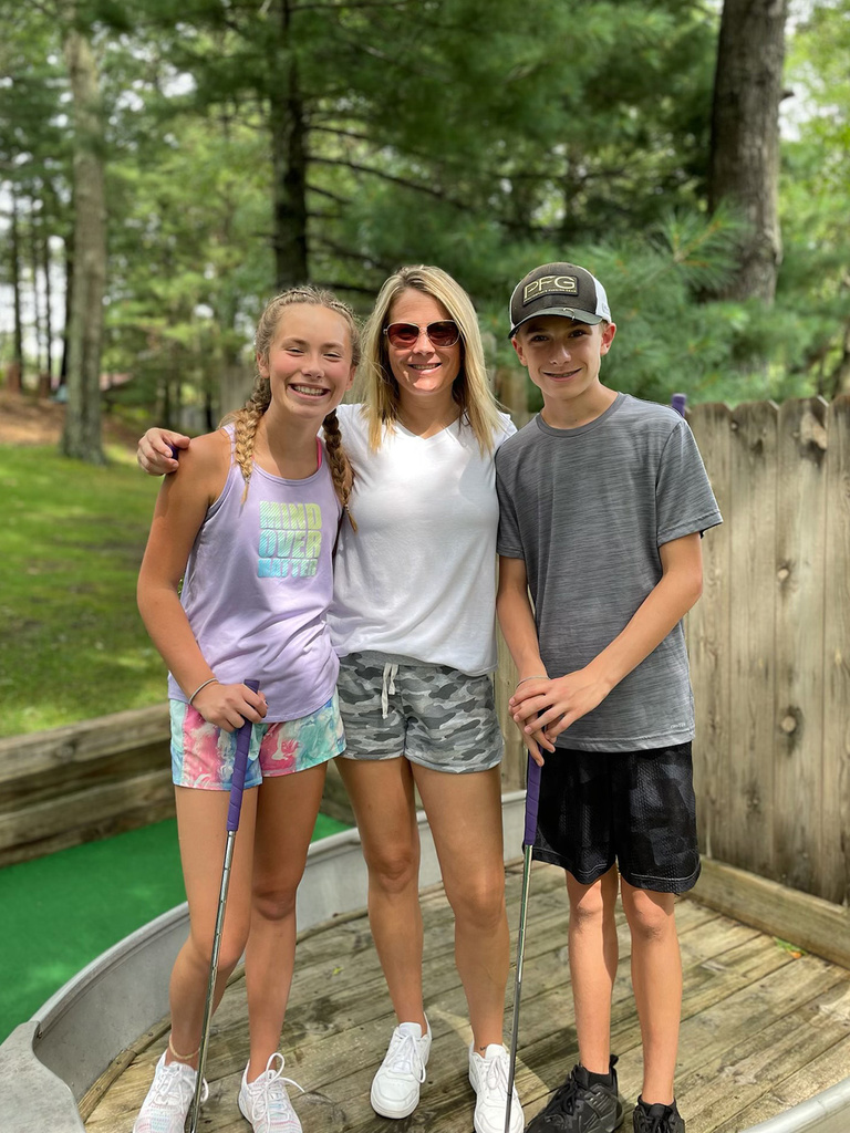 a woman with an arm around each of her two kids