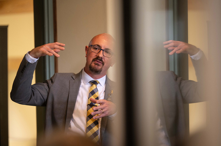 David Miles giving a talk, with a reflection of his image to the right