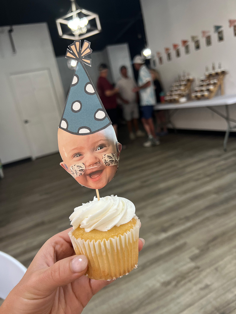 a cupcake with a topper that features Nash Keen's face