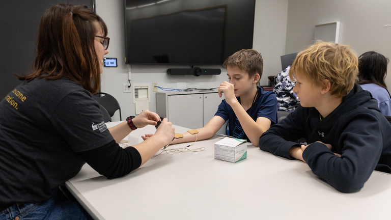 students participate in an experiment at a Kids Go STEM event
