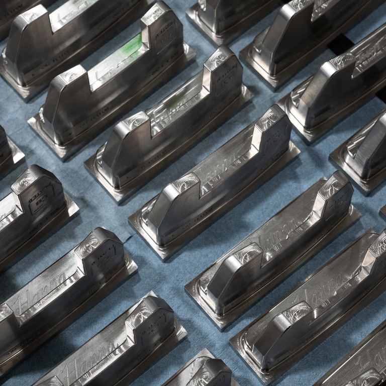 rows of Hanna Golf putter heads, arranged at a diagonal angle