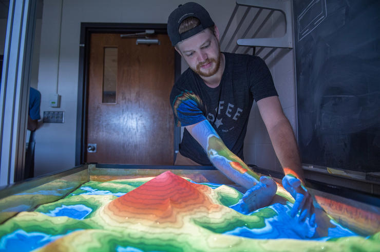 Student in the Department of Physics and Astronomy works on an augmented-reality sandbox where users can design their own universe and then watch how gravity affects an object as it travels through the imagined environment.
