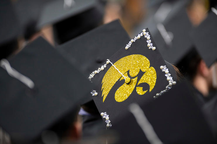 graduation caps at a commencement ceremony, one with a tigerhawk logo