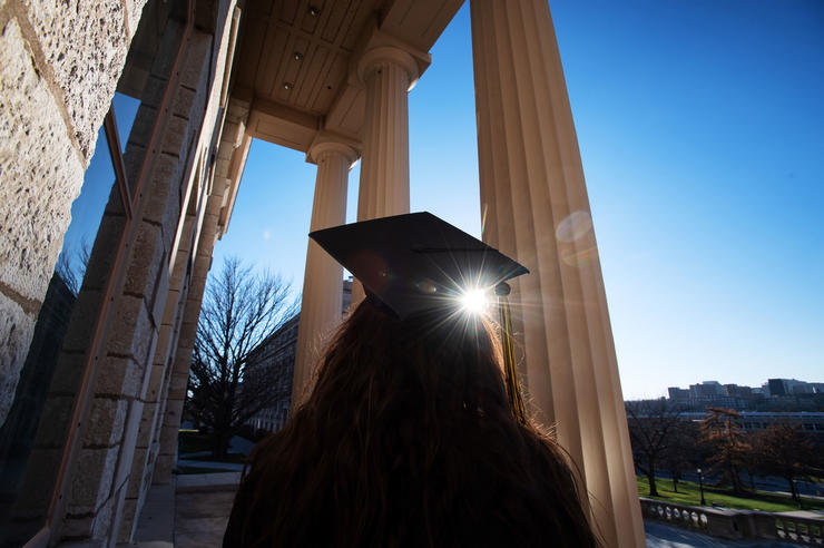Graduate looking up toward Old Capital pillars