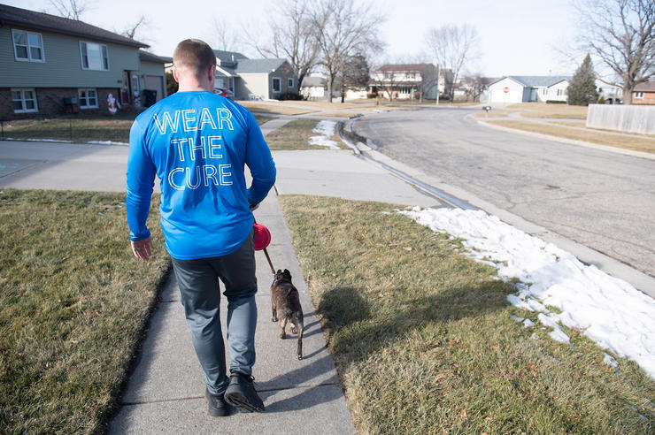a man walking his dog through a neighborhood