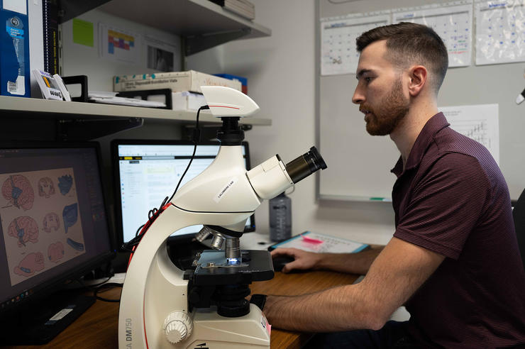 University of Iowa doctoral student Matt McGregor works at a desk in a lab