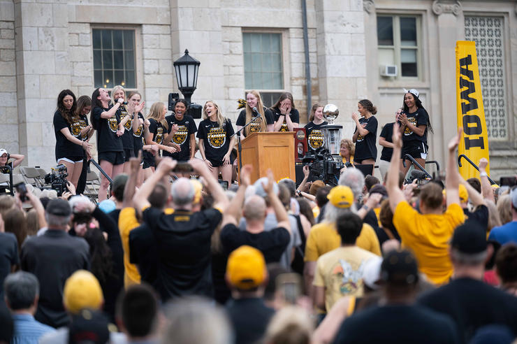 the Iowa women's basketball team celebrates with fans on the Pentacrest