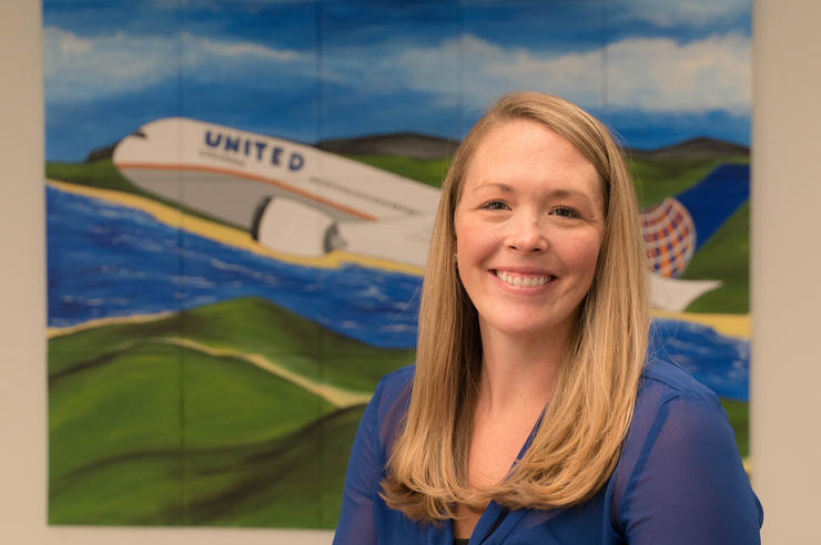 Michelle McCarthy, University of Iowa alumna, posing for a portrait in front of a United Airlines mural
