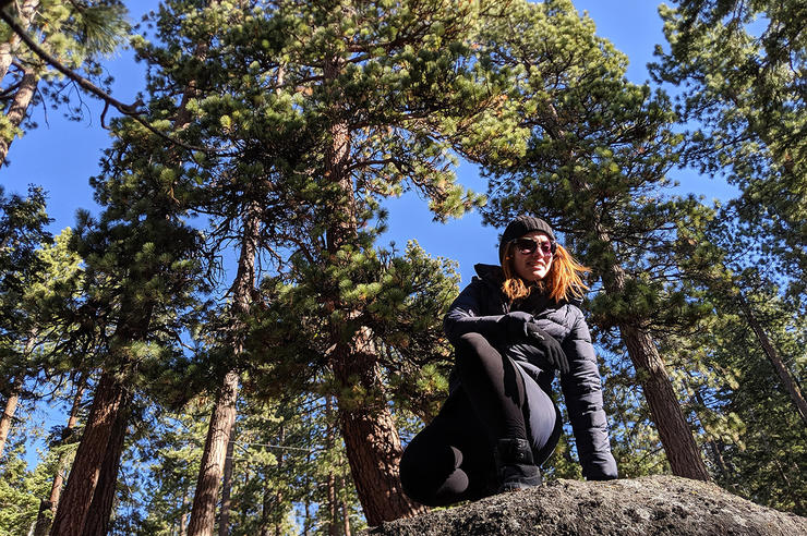 university of iowa alum lauryn ash on a boulder in a forest