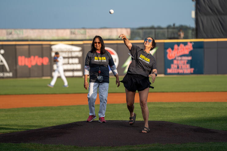 a woman throwing out the first pitch at a baseball game