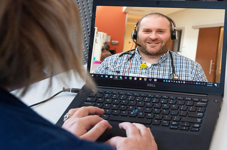 patient speaking with a health care professional via video call on a computer