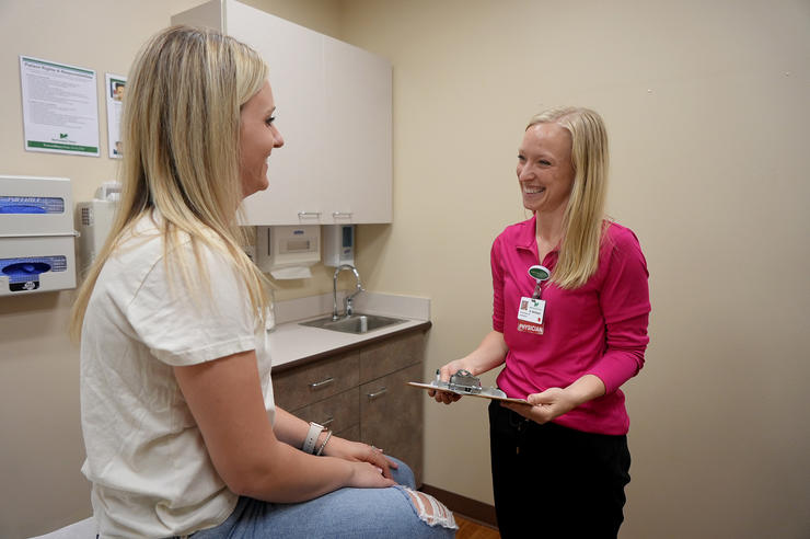 University of Iowa alum Ericka Muhlbauer meets with a patient in an exam room