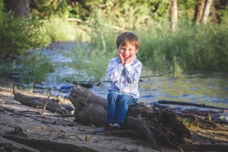 Tate Manahl sits outdoors; when he was 3, he was injured in a lawn mowing incident, and university of iowa health care professionals performed numerous procedures to save his life and his legs