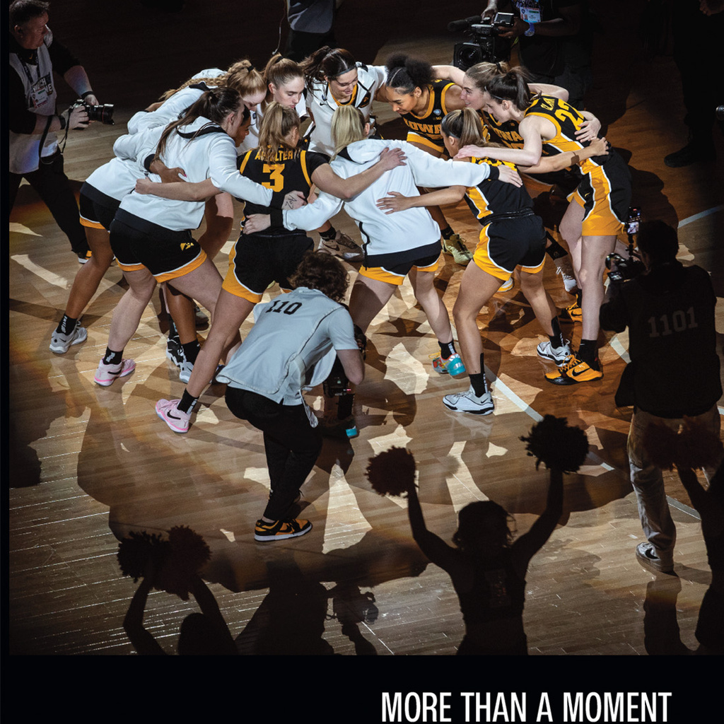 cover image for the book More Than a Moment, which shows the University of Iowa women's basketball team huddled on the court